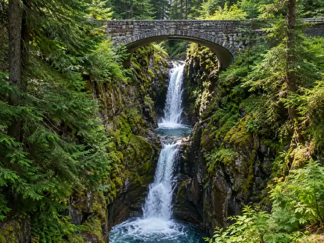 Die Christine Falls unter ihrer gewölbten steinernen Straßenbrücke