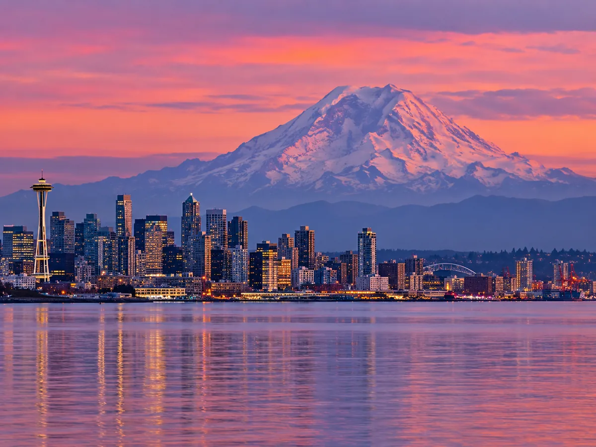 Die Skyline von Seattle in der Abenddämmerung, dahinter der Mount Rainier am Horizont
